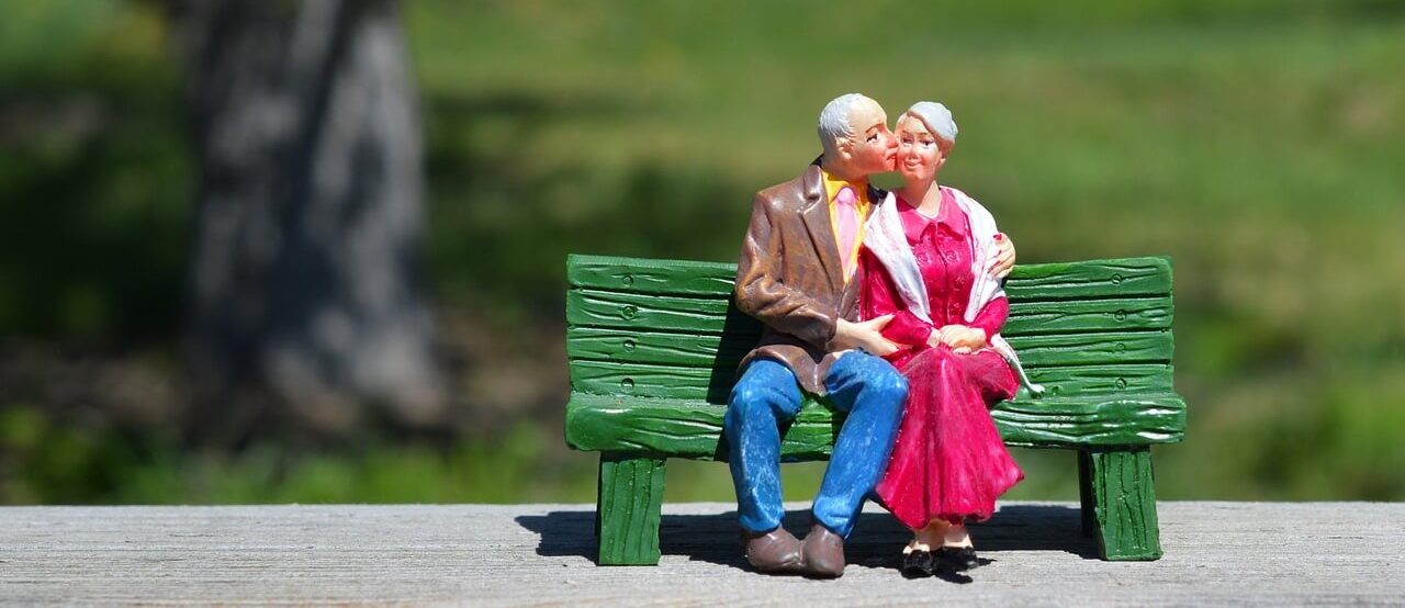 Figura de um casal sentado num banco