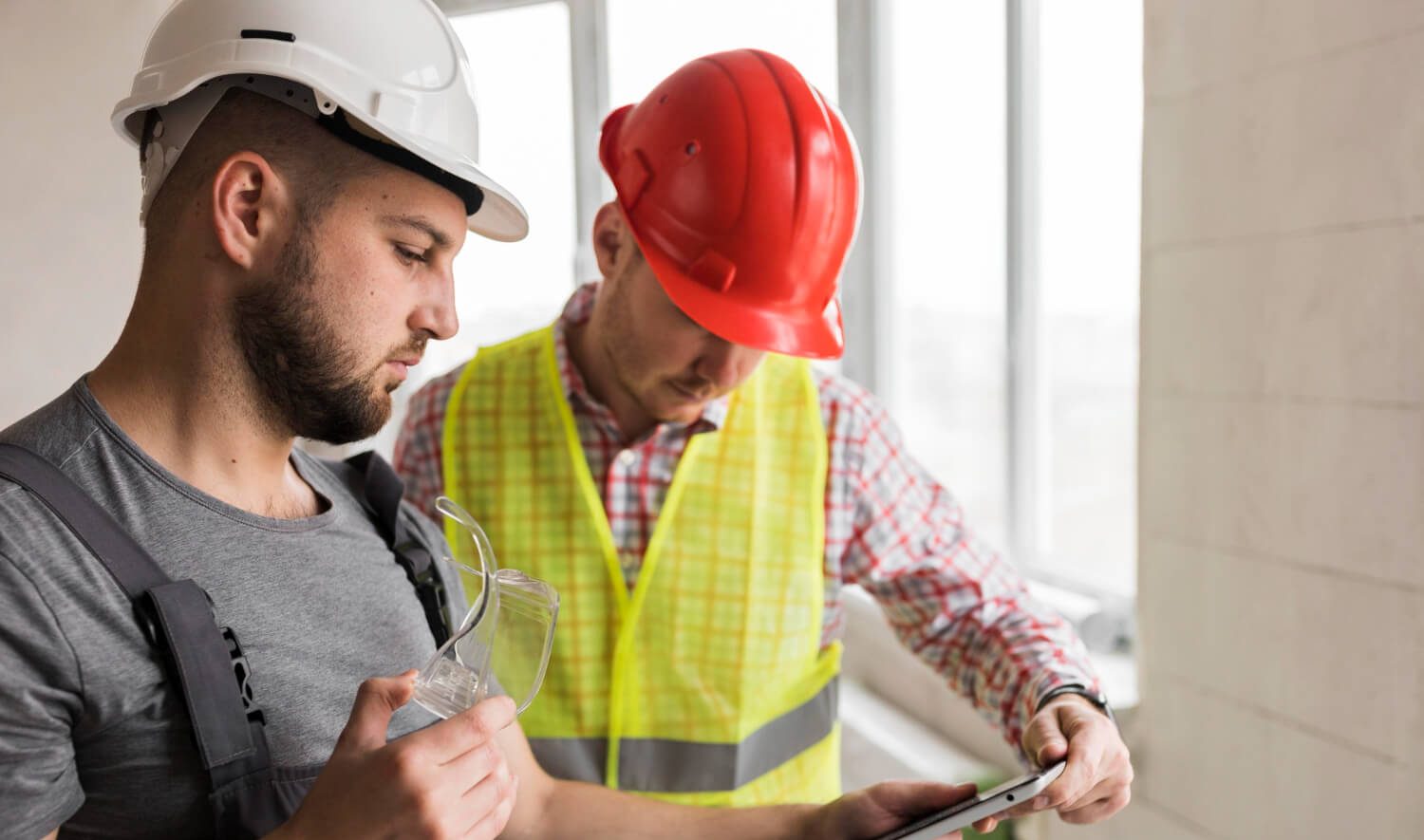 Dois trabalhadores da construção civil com o equipamento de proteção