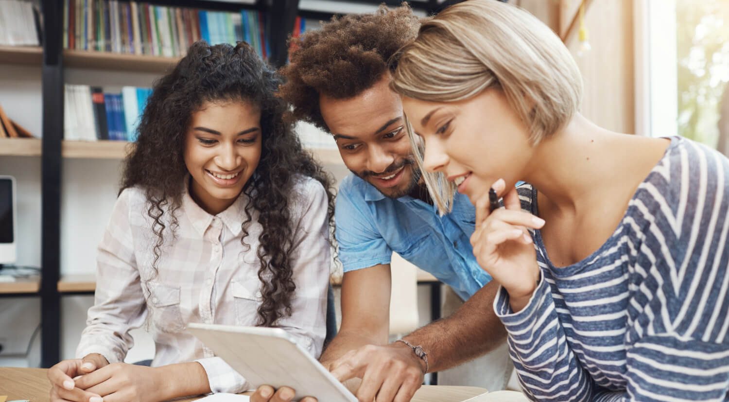 Grupo de estudantes universitários a ver um tablet