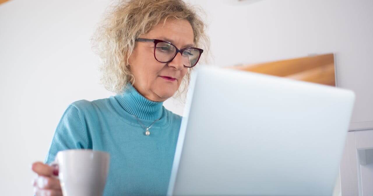 Senhora no computador a beber um café