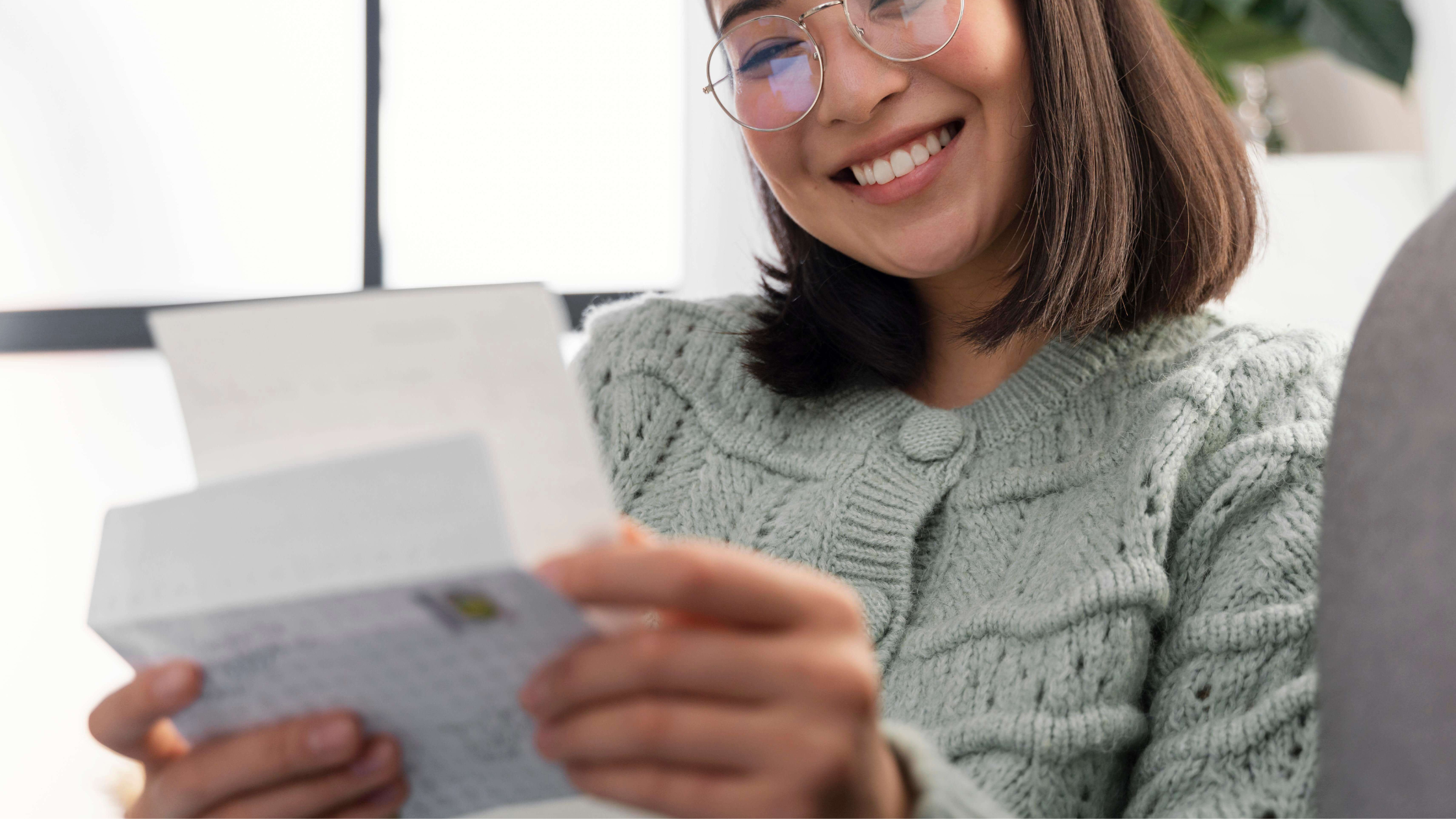 Mulher portuguesa a sorrir enquanto lê um documento sobre o aumento do salário mínimo e das pensões em 2026.