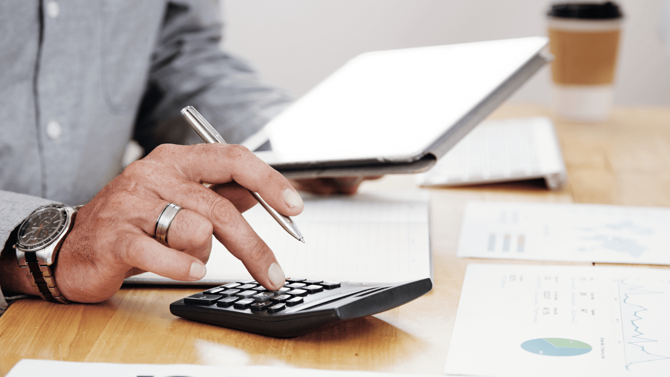 Mão utilizando uma calculadora para preencher impostos em Portugal — conceito de contabilidade, finanças pessoais e declaração de IRS/IRC.