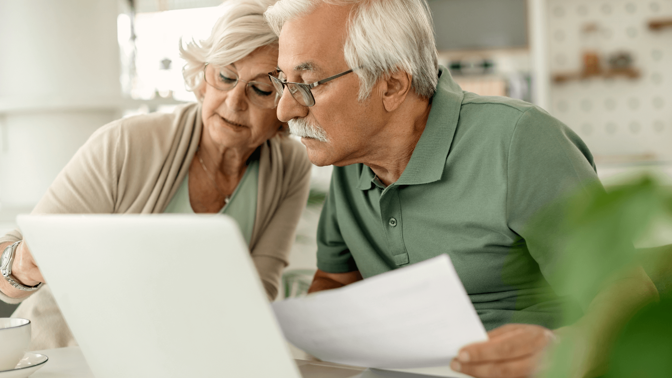 Casal de reformados a poupar dinheiro nas contas de energia, analisando faturas e adotando medidas de eficiência energética.