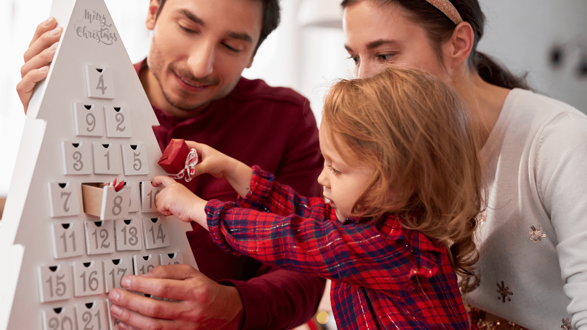 Família a preparar o orçamento de Natal 2025 com lista de despesas e árvore decorada