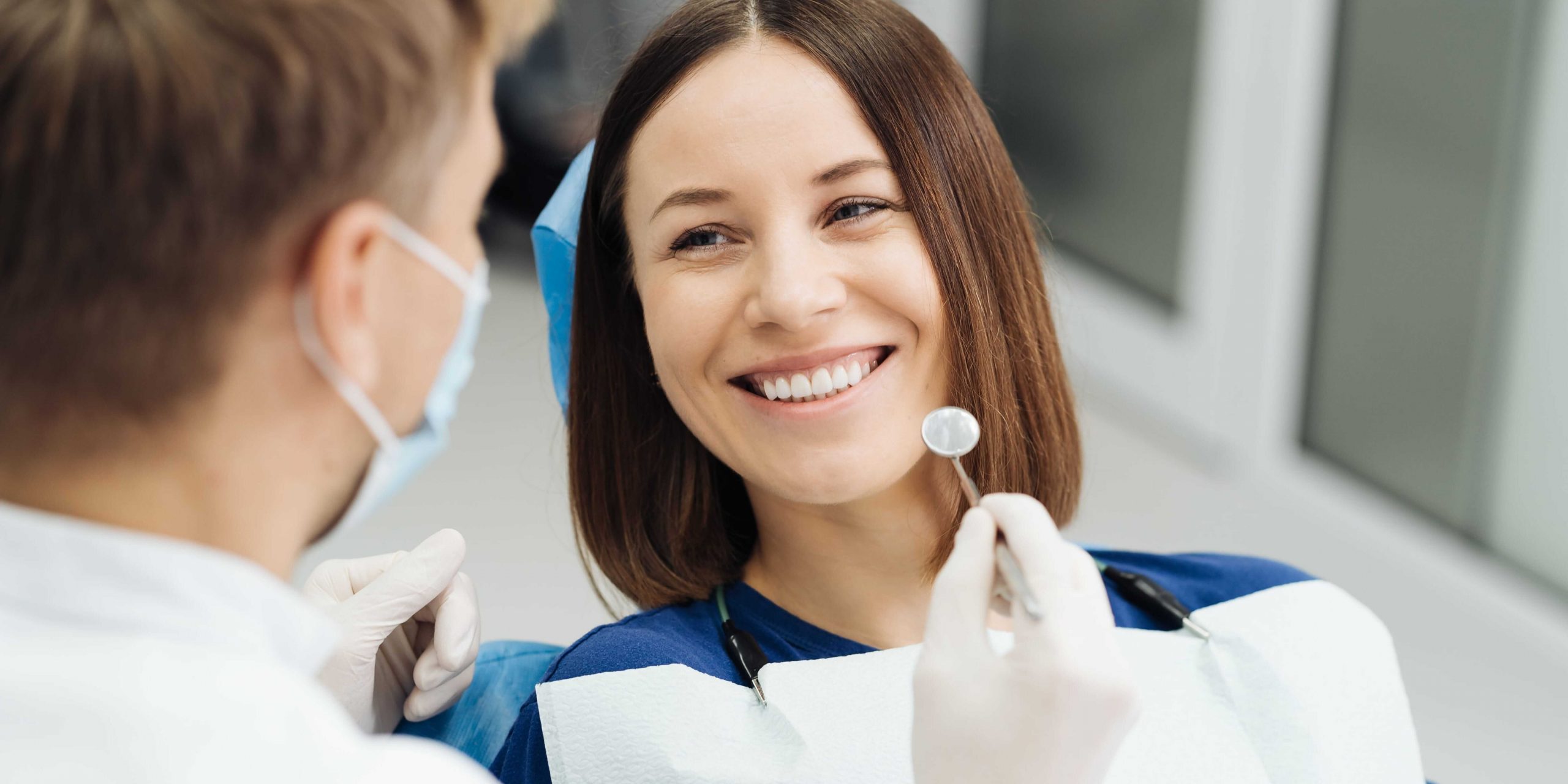 Paciente numa consulta de saúde oral com dentista, ilustrando cuidados dentários, acompanhamento clínico e acesso a tratamentos como o cheque-prótese no SNS.