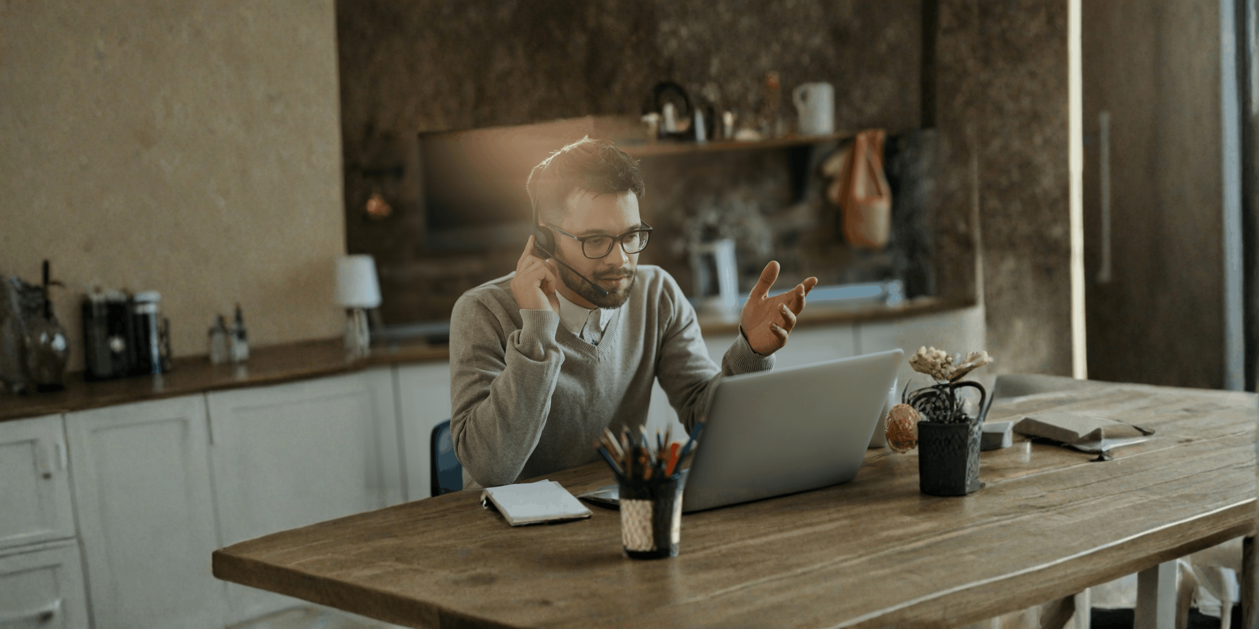 Homem a utilizar o computador portátil em casa durante uma videochamada, ilustrando o atendimento online da Loja de Cidadão Virtual e o acesso a serviços públicos à distância.