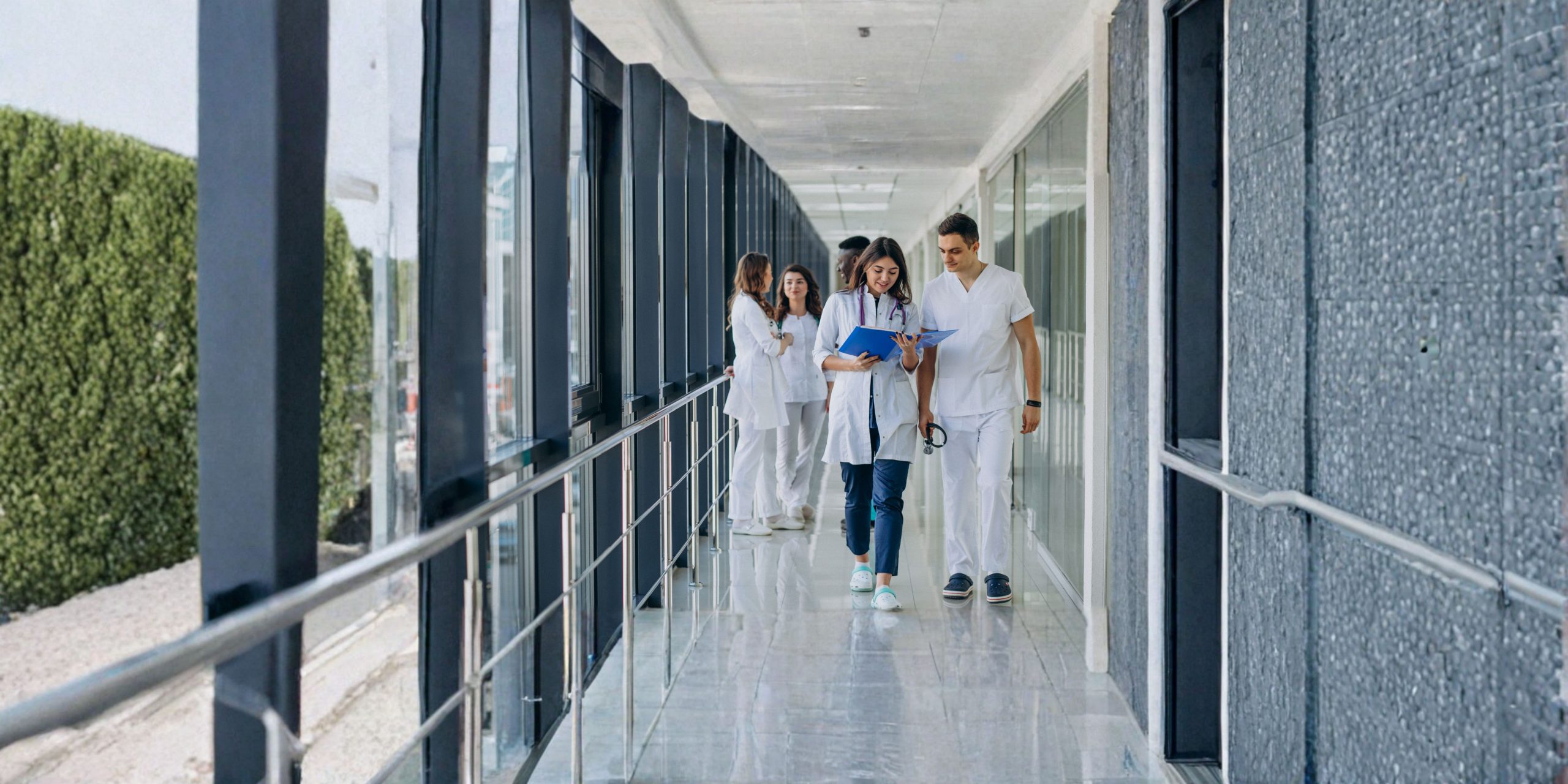 Profissionais de saúde num corredor hospitalar, imagem ilustrativa sobre médico de família, SNS e acesso aos cuidados de saúde em Portugal.