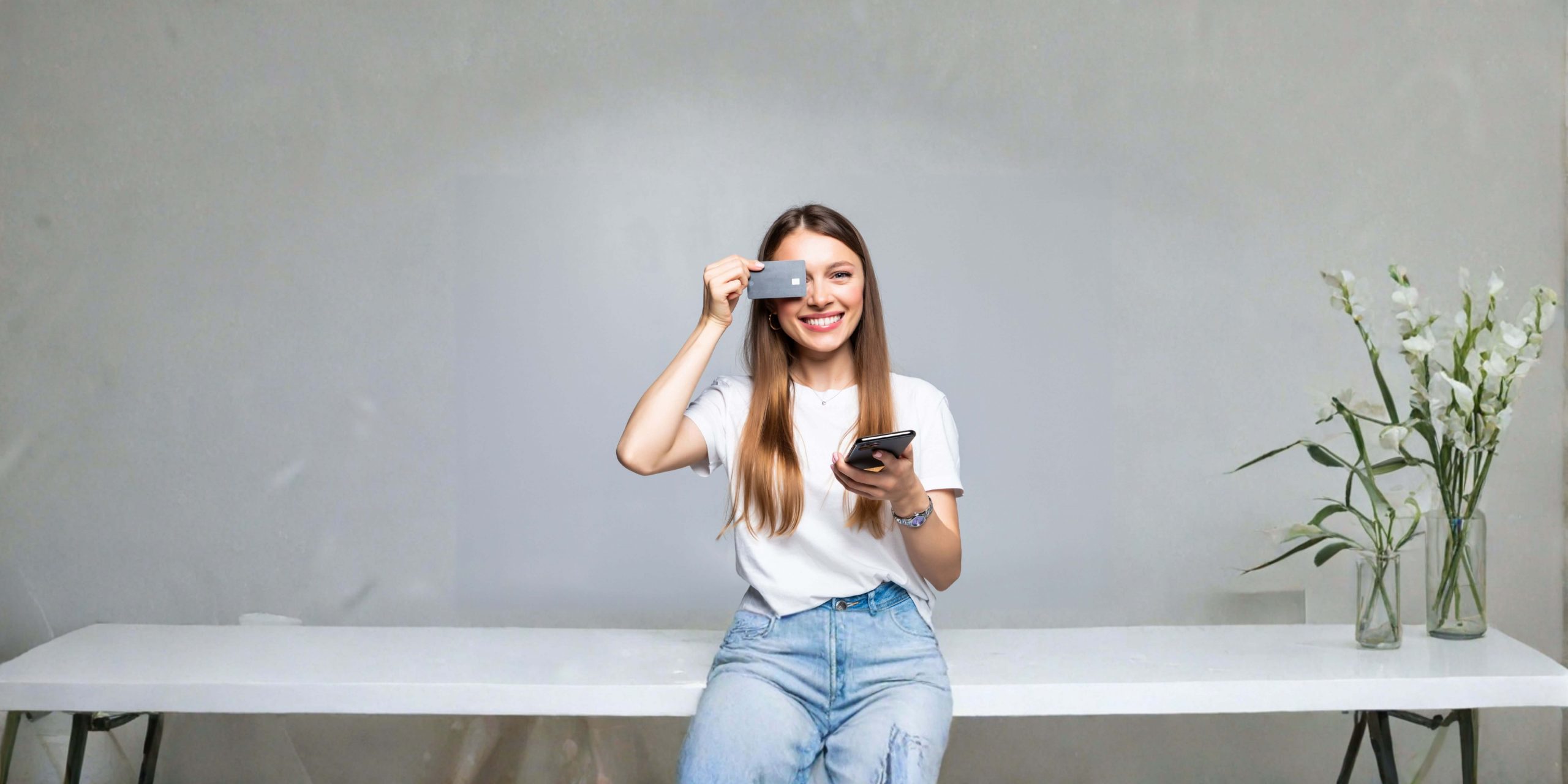 Mulher a utilizar cartão de crédito e telemóvel, imagem sobre pagamentos digitais e cartão de crédito em Portugal.