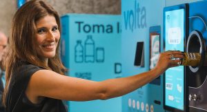 Pessoa a devolver uma embalagem numa máquina do Sistema Volta para receber o reembolso do depósito em Portugal.