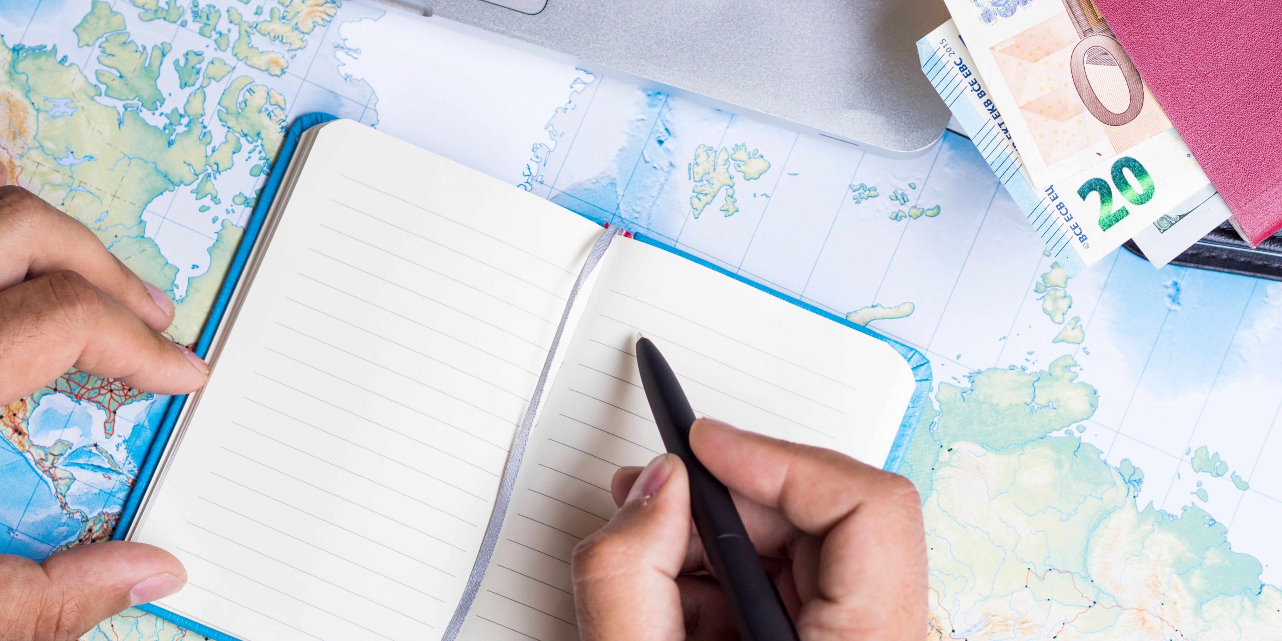 Pessoa a planear despesas e rendimentos de trabalho entre Portugal e Espanha, com mapa, caderno e notas financeiras sobre dupla tributação e residência fiscal.