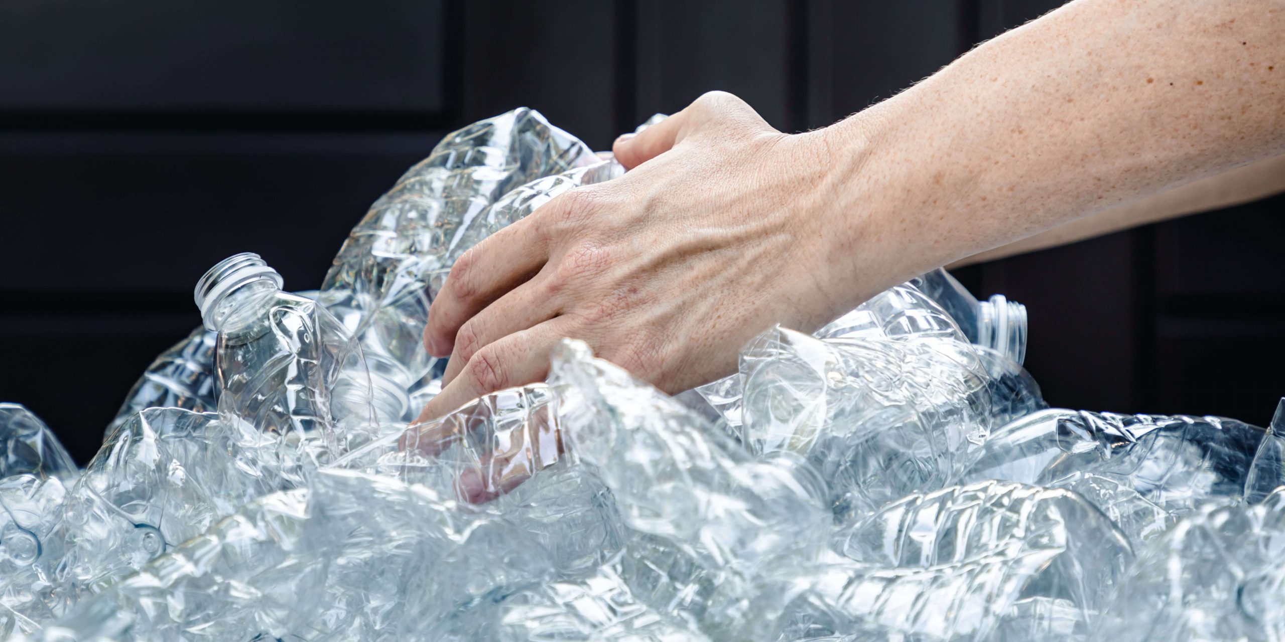 Pessoa a separar garrafas de plástico para reciclagem no âmbito do Sistema Volta de depósito e reembolso de embalagens em Portugal.
