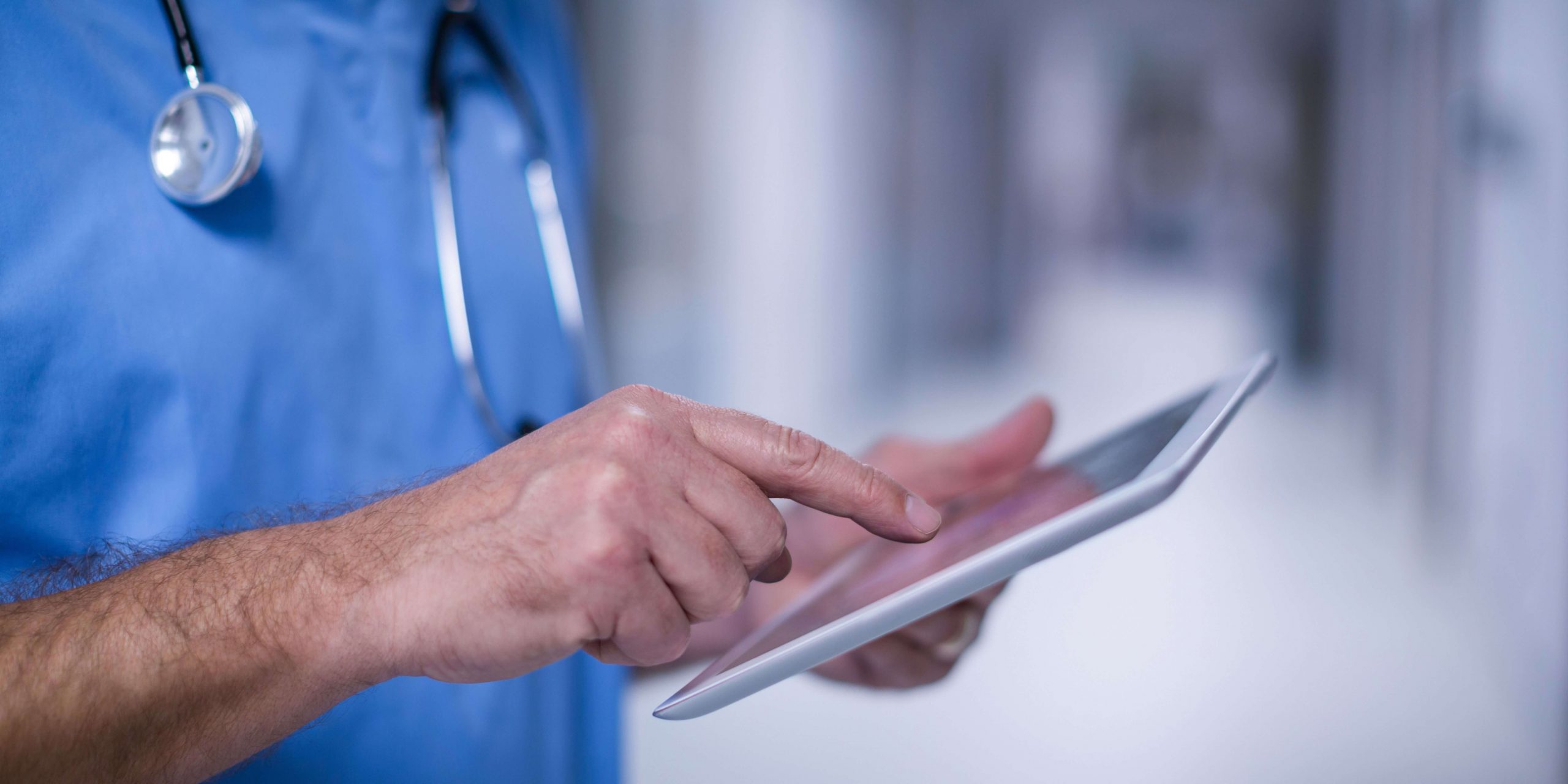 Profissional de saúde utiliza tablet para aceder a serviços digitais do SNS 24 e apoiar a triagem de sintomas dos utentes.
