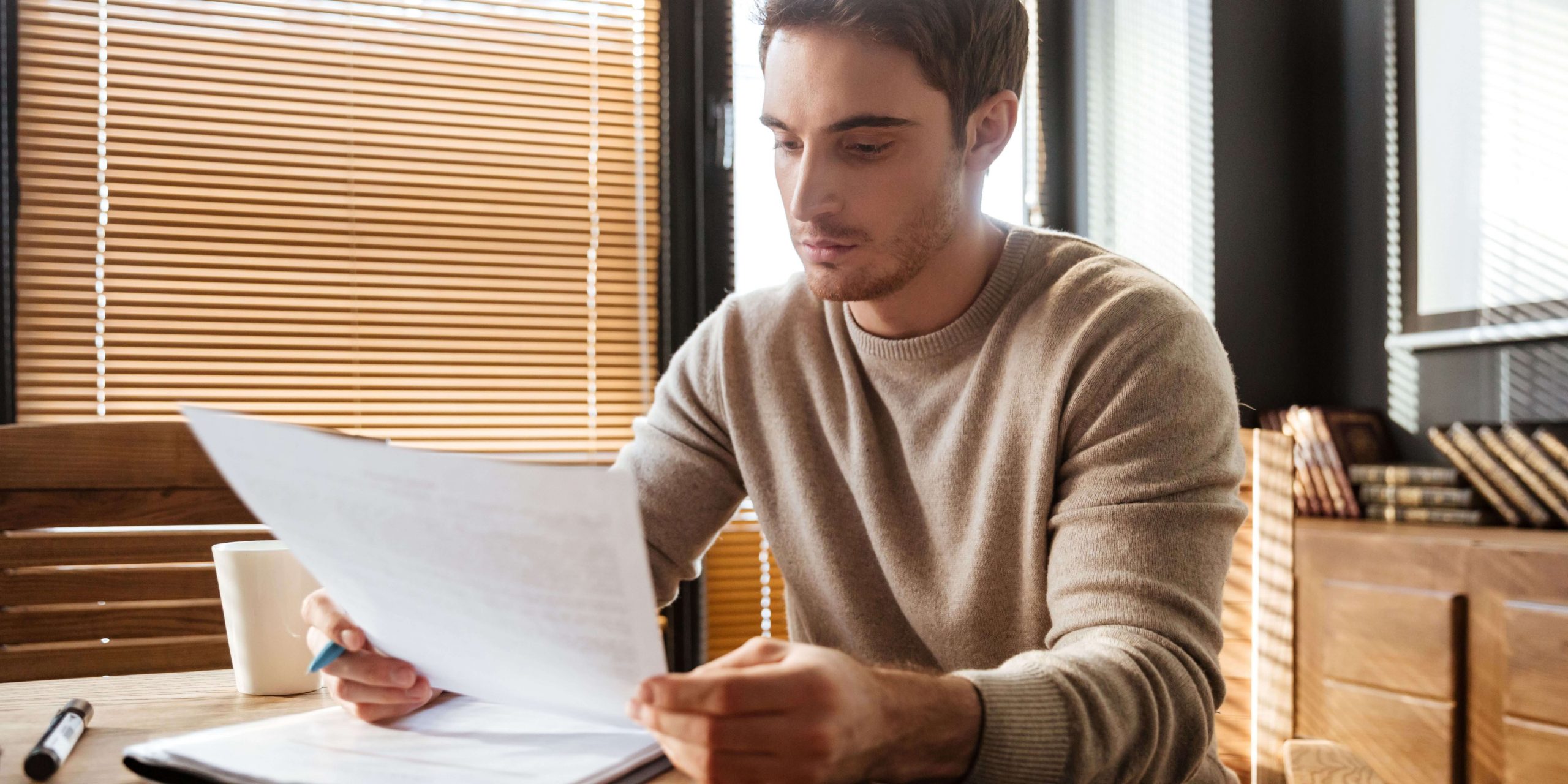 Homem a analisar documentos relacionados com a prestação compensatória do subsídio de férias e os valores pagos pela Segurança Social. 