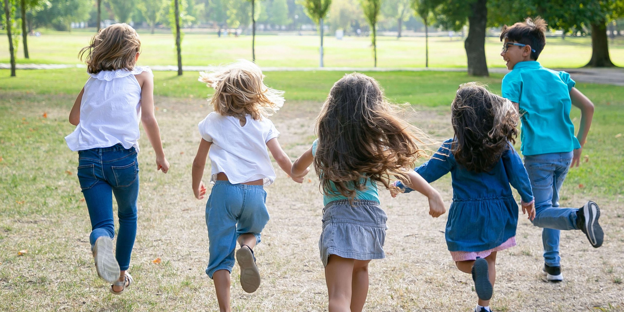 Crianças a correr num parque, representando a proteção, o bem-estar e o apoio financeiro garantido pelo Fundo de Garantia dos Alimentos Devidos a Menores.